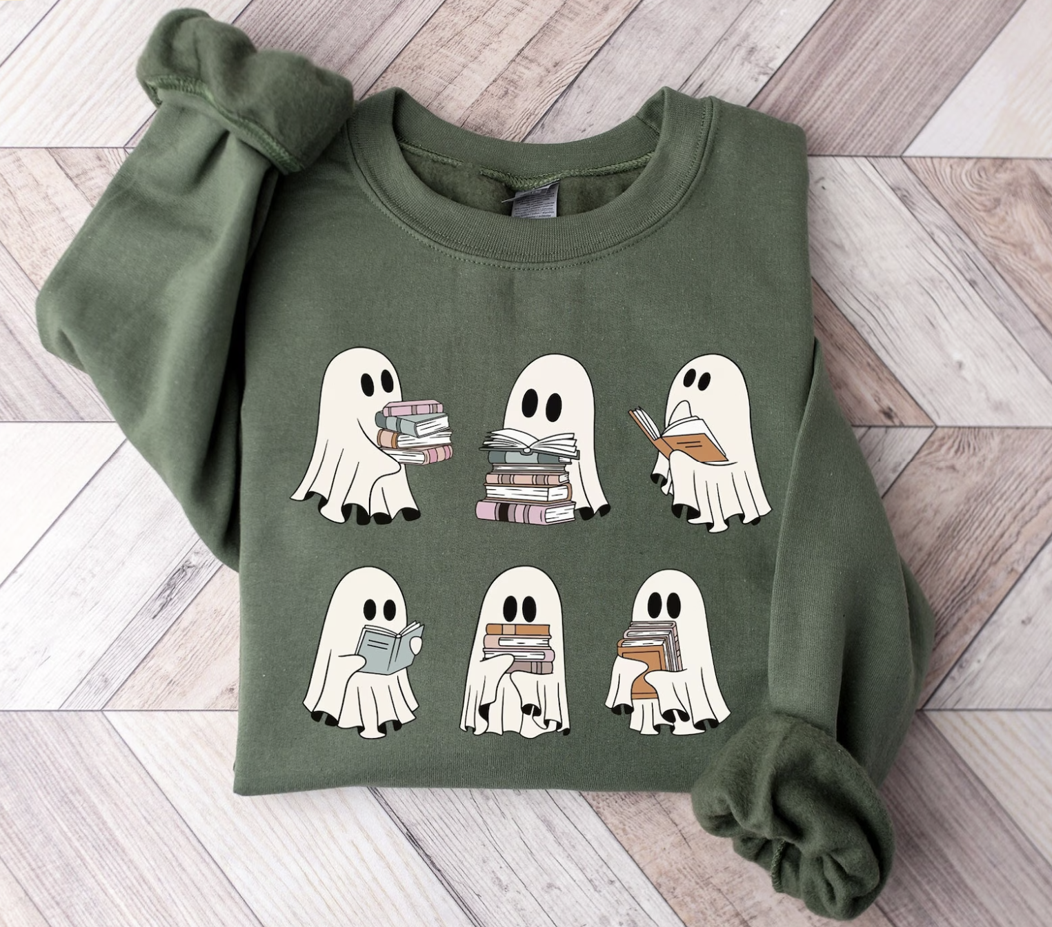 Sage green sweatshirt featuring six cute illustrated ghosts in two rows holding stacks of books.
