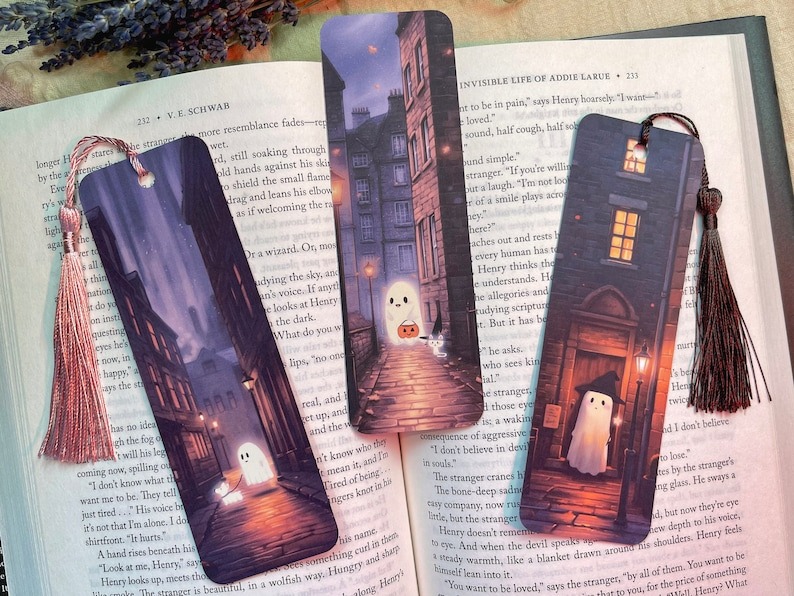 a photo of three bookmarks with cute ghosts in Edinburgh streets at night