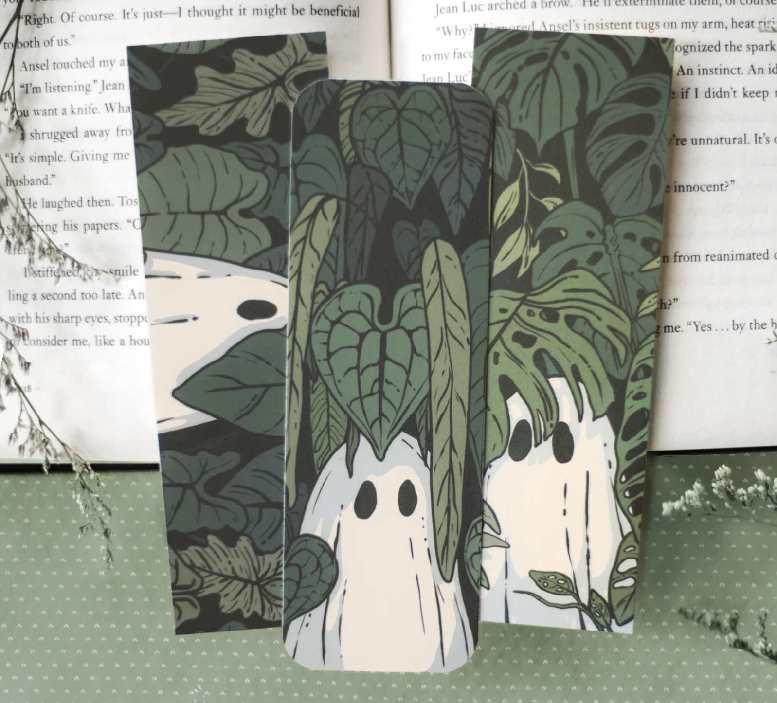 Three bookmarks featuring lush green houseplants with sheet ghosts peeking out through the foliage.