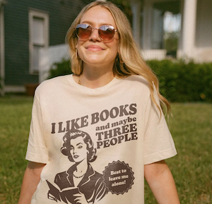 a tshirt with the graphic of a woman reading with text saying "I like books and maybe 3 people best to leave me alone"