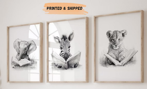 three framed black and white illustrations of a baby elephant, tiger, and zebra reading a book