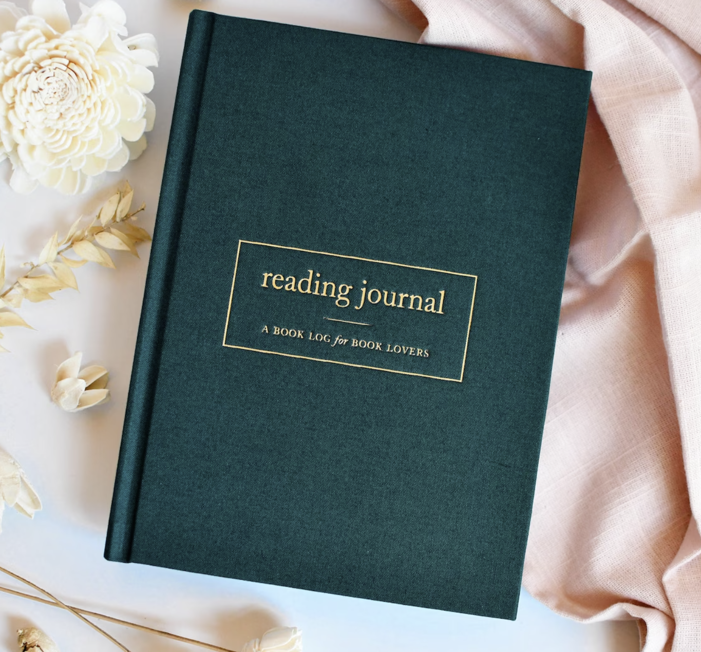 Dark green hardbound reading journal with gold text in the center of a small rectangular border that says: "Reading Journal. A Book log for Book lovers." 