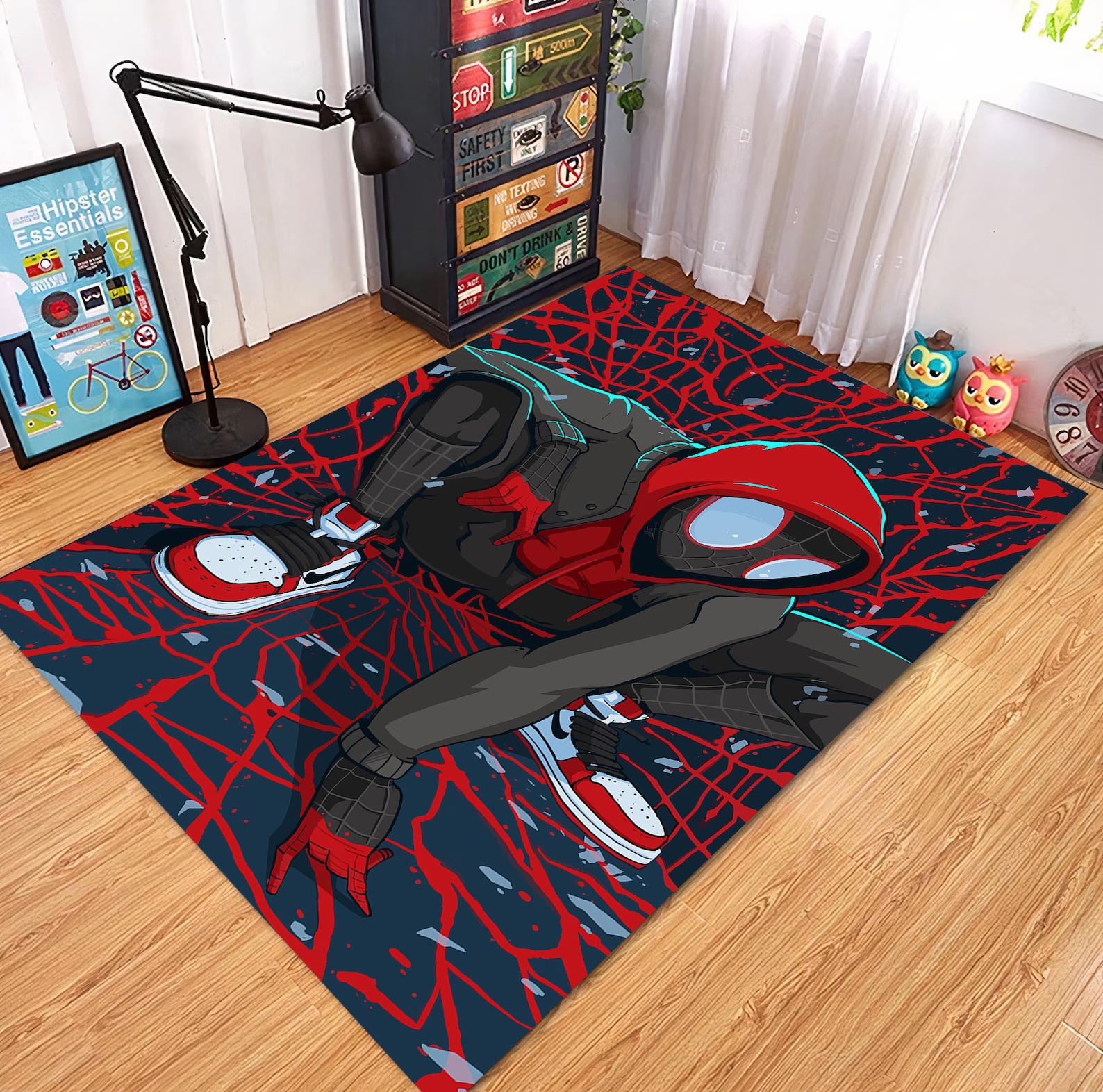 A rectangular rug on a wooden floor. The rug is black and red and features an image of Miles Morales as Spider-Man, squatting amid a red web pattern