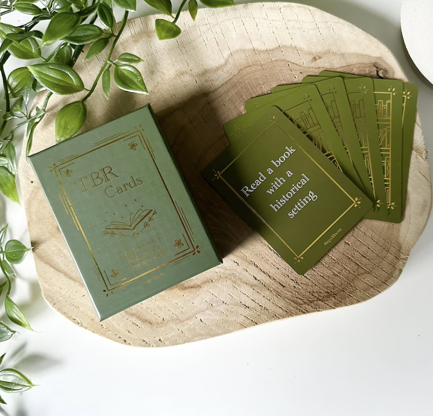 Spread of fern green card deck with prompts such as "Read a book with a historical setting." 
