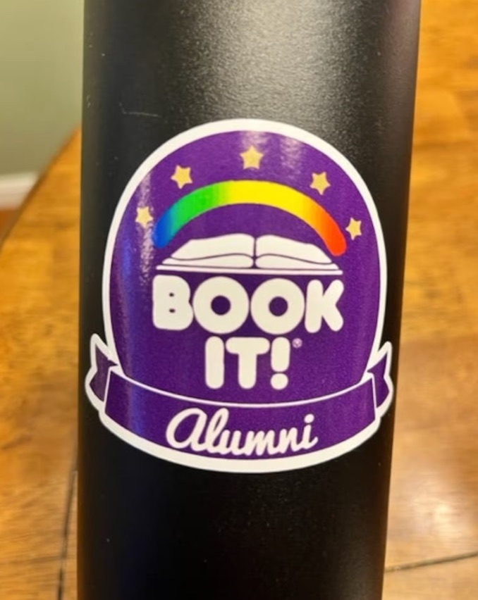 round purple sticker that sys "book it alumni."