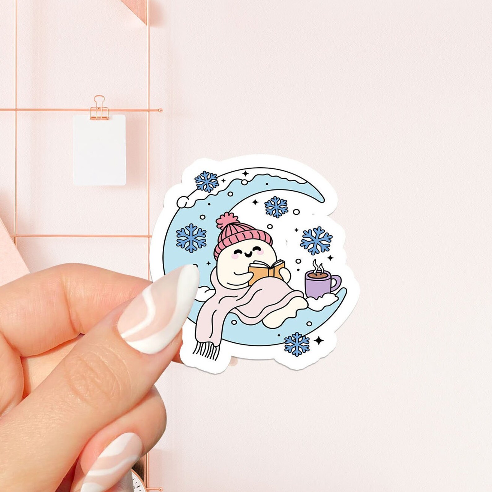 image of a sticker with a cute creature reading on the moon