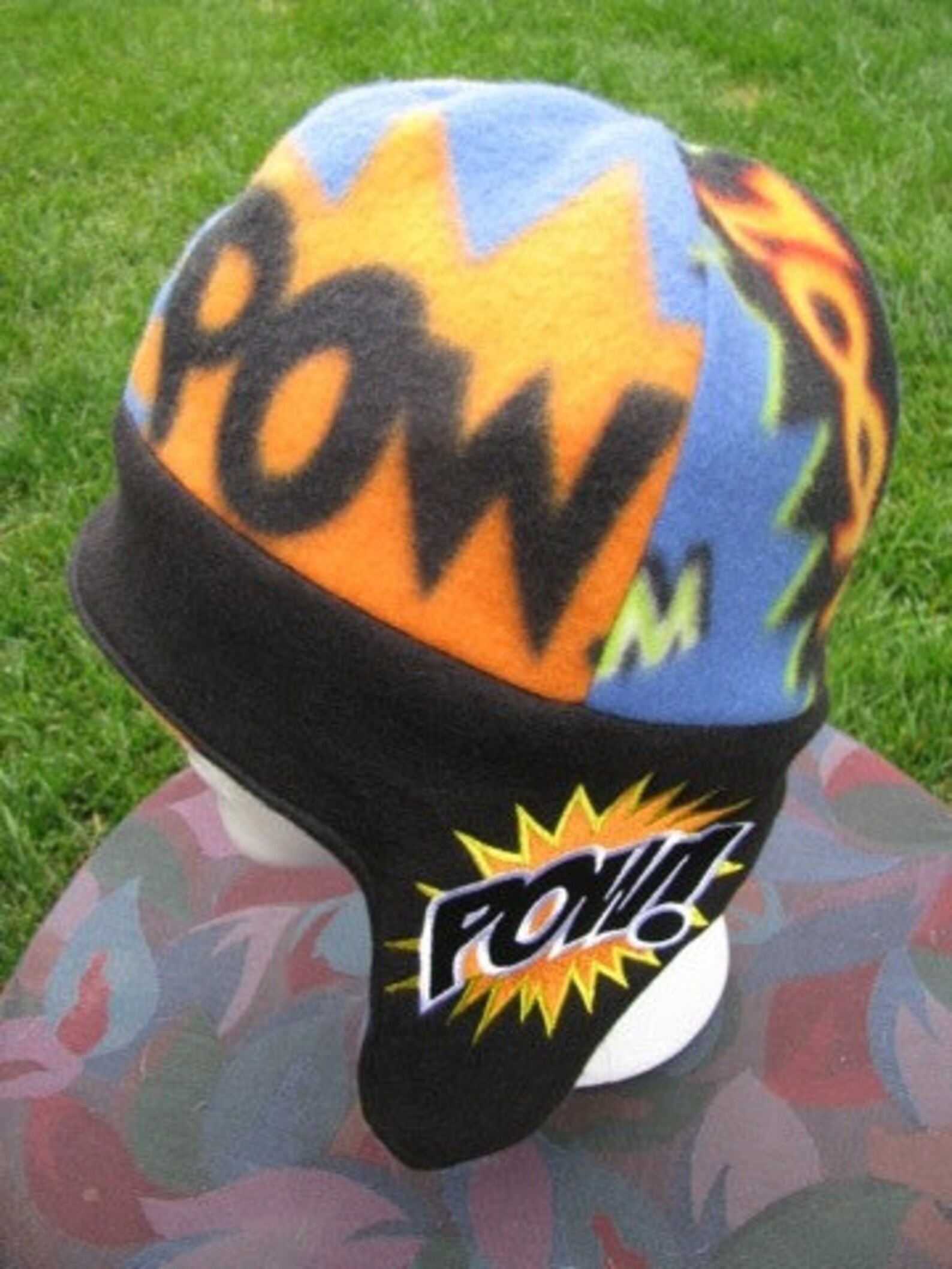 A mannequin wearing a soft hat with ear flaps and covered in comics-style onomatopoeias