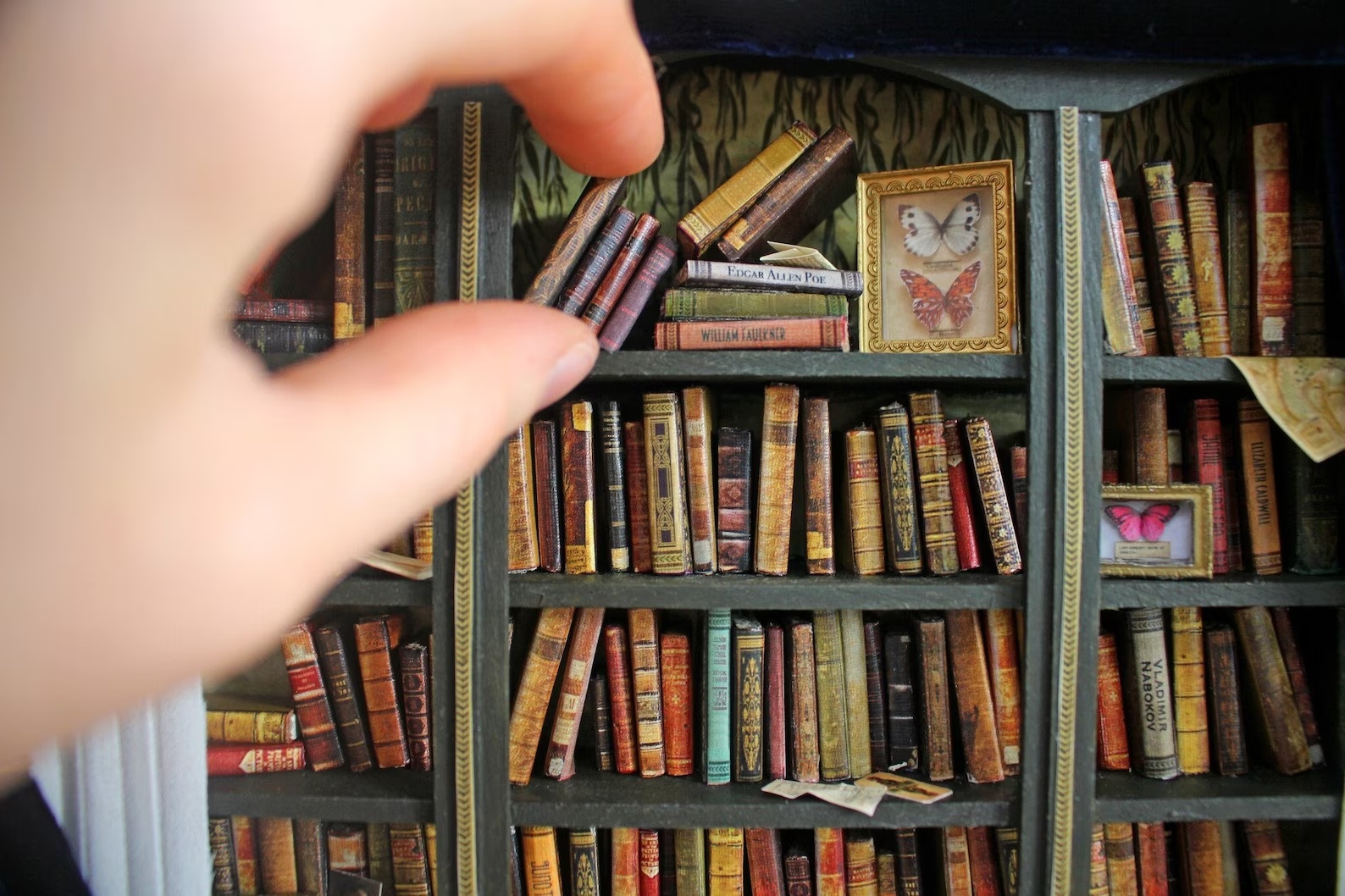 a photo of a very tiny bookshelf miniature with very tiny books