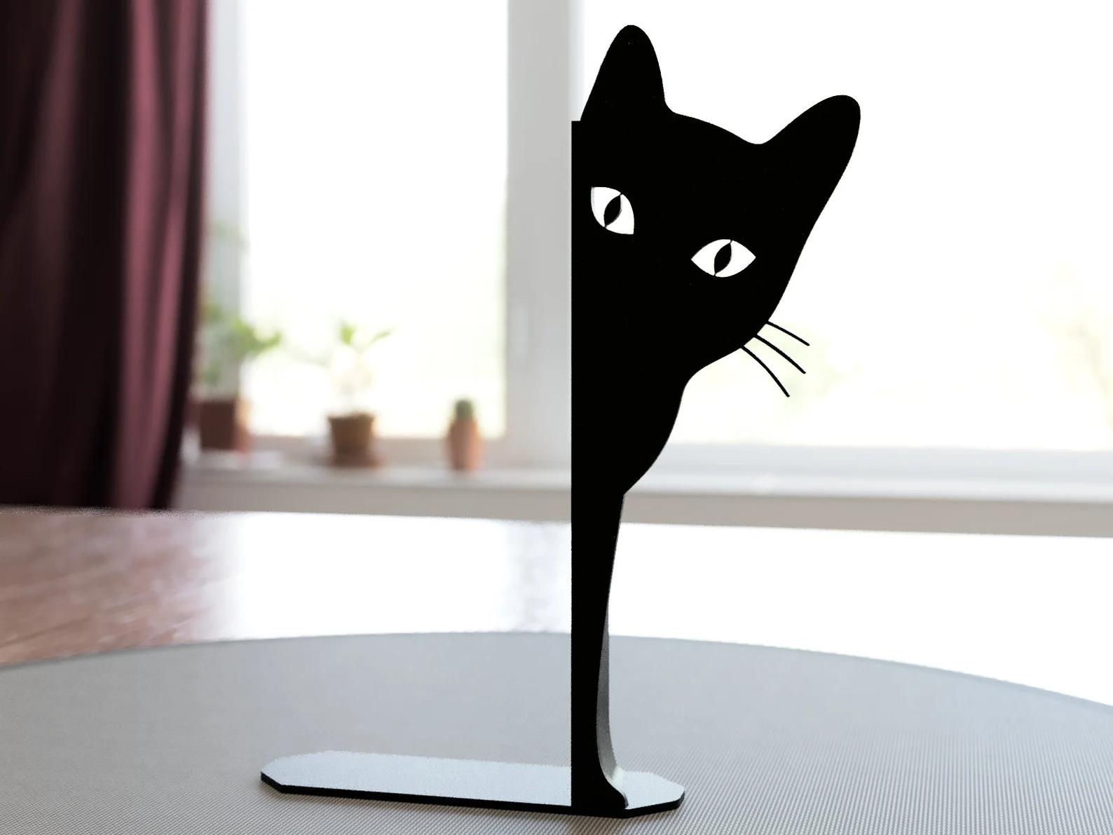 a photo of a bookend made of metal. It's shaped like a black cat.