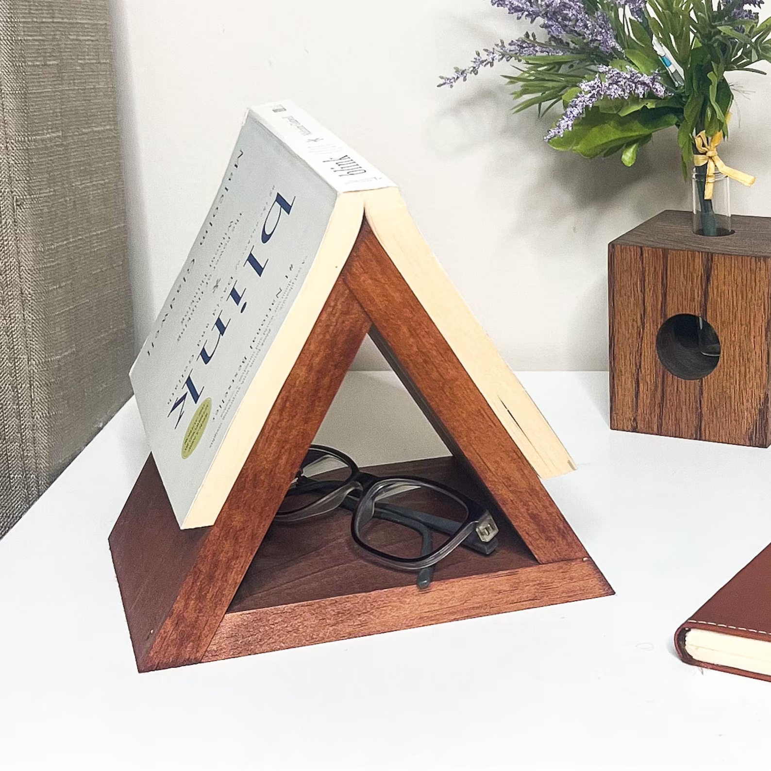 a photo of a wooden triangle that is built to hold a book open.