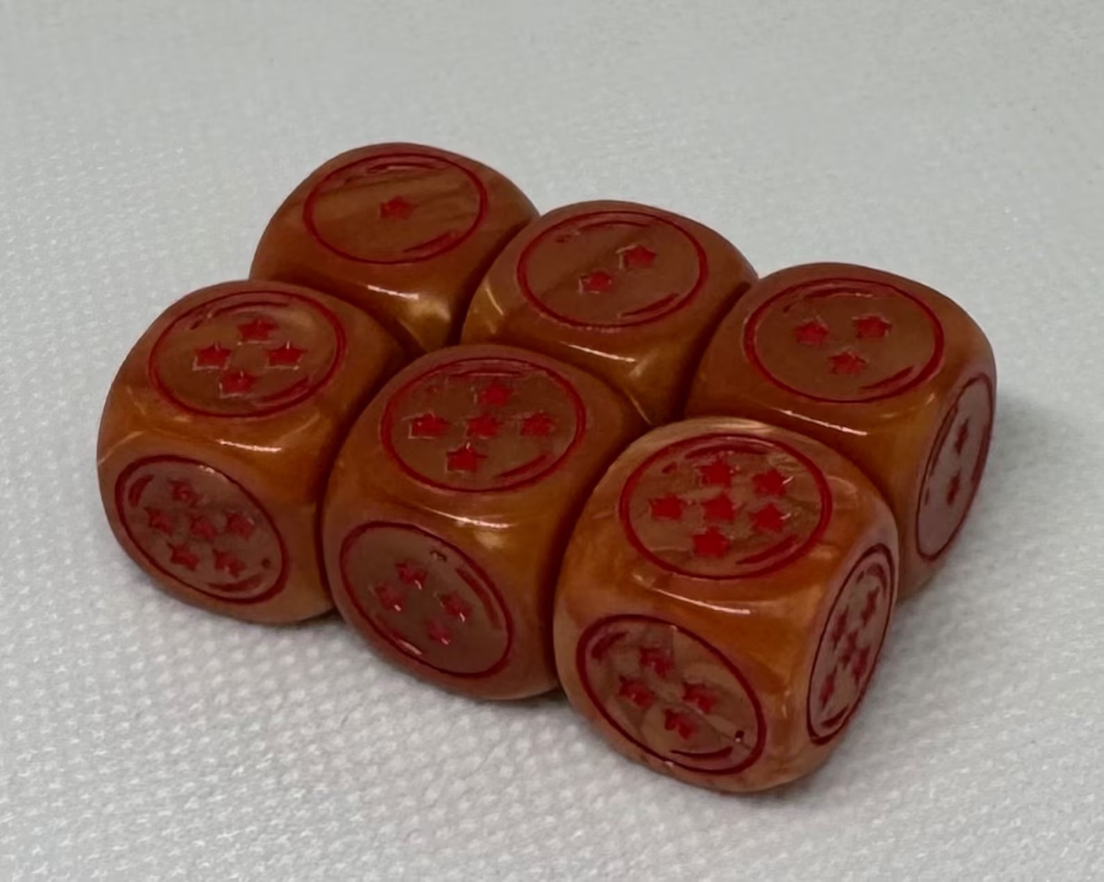 A set of six orange dice with red stars, inspired by Dragon Ball