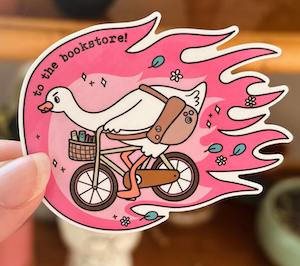 illustrated sticker of a goose on a bike peddling fast that says "to the bookstore!"