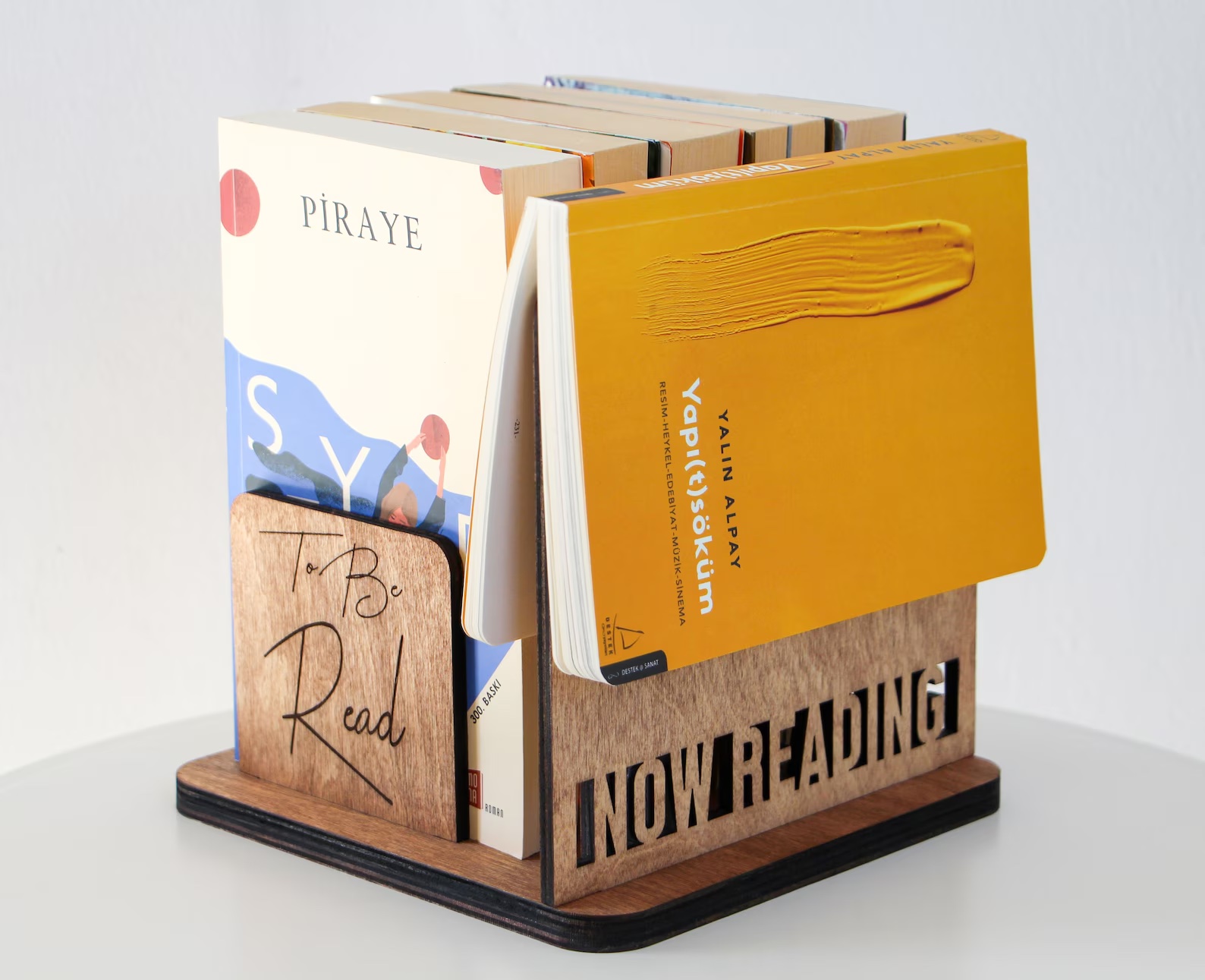 a photo of a wooden book holder that say "now reading" on the side