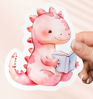 illustrated sticker of a pink dinosaur reading a book