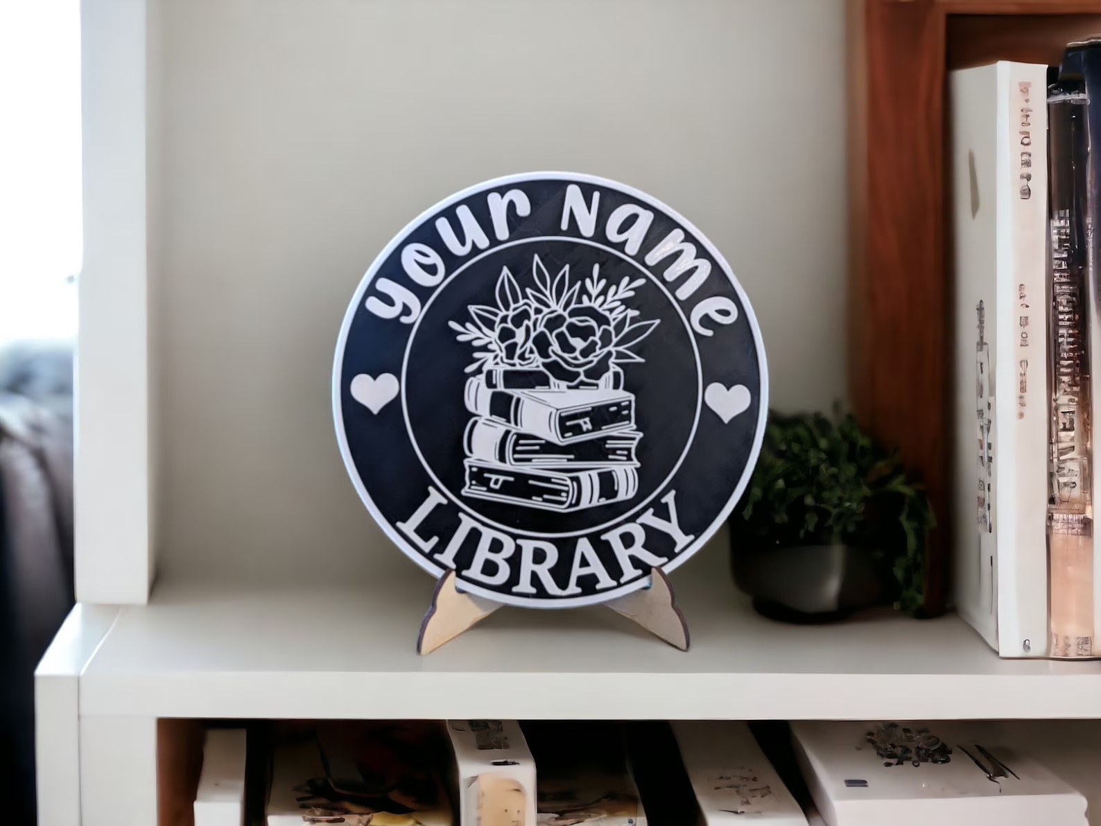 a photo of a library plate on a little stand. It has a blank place for your name and says library at the bottom. A little book stack is in the center.