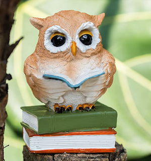 miniature figurine of an owl on a stack of books reading