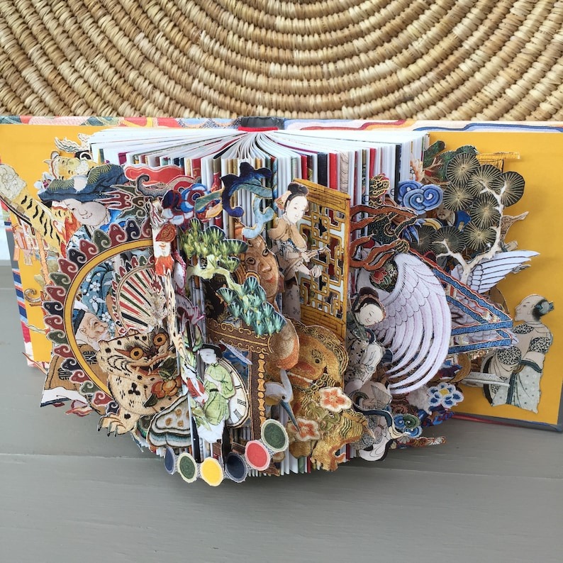 a book sculpture with the illustrations in a book cut out and rearranged