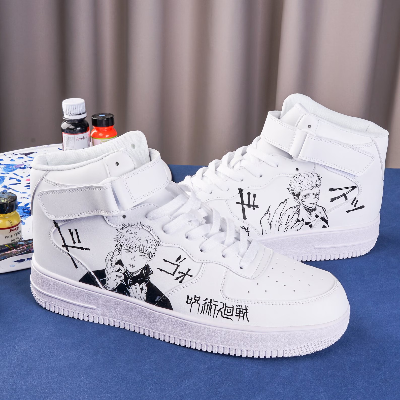 A pair of white sneakers with manga characters painted in black