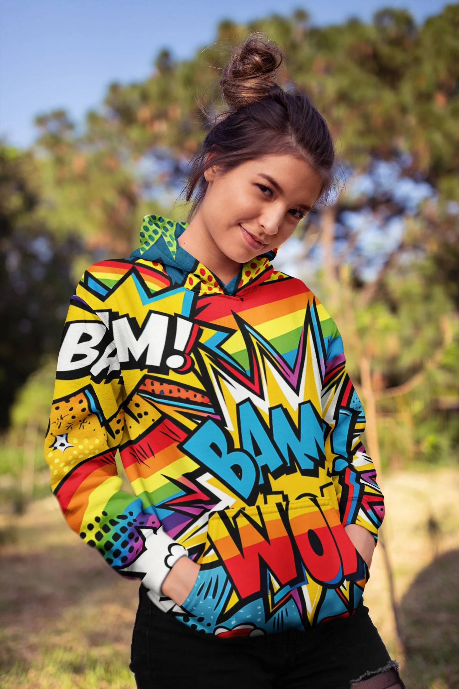 A person wearing a rainbow-striped hoodie with comic book-style onomatopoeias on it