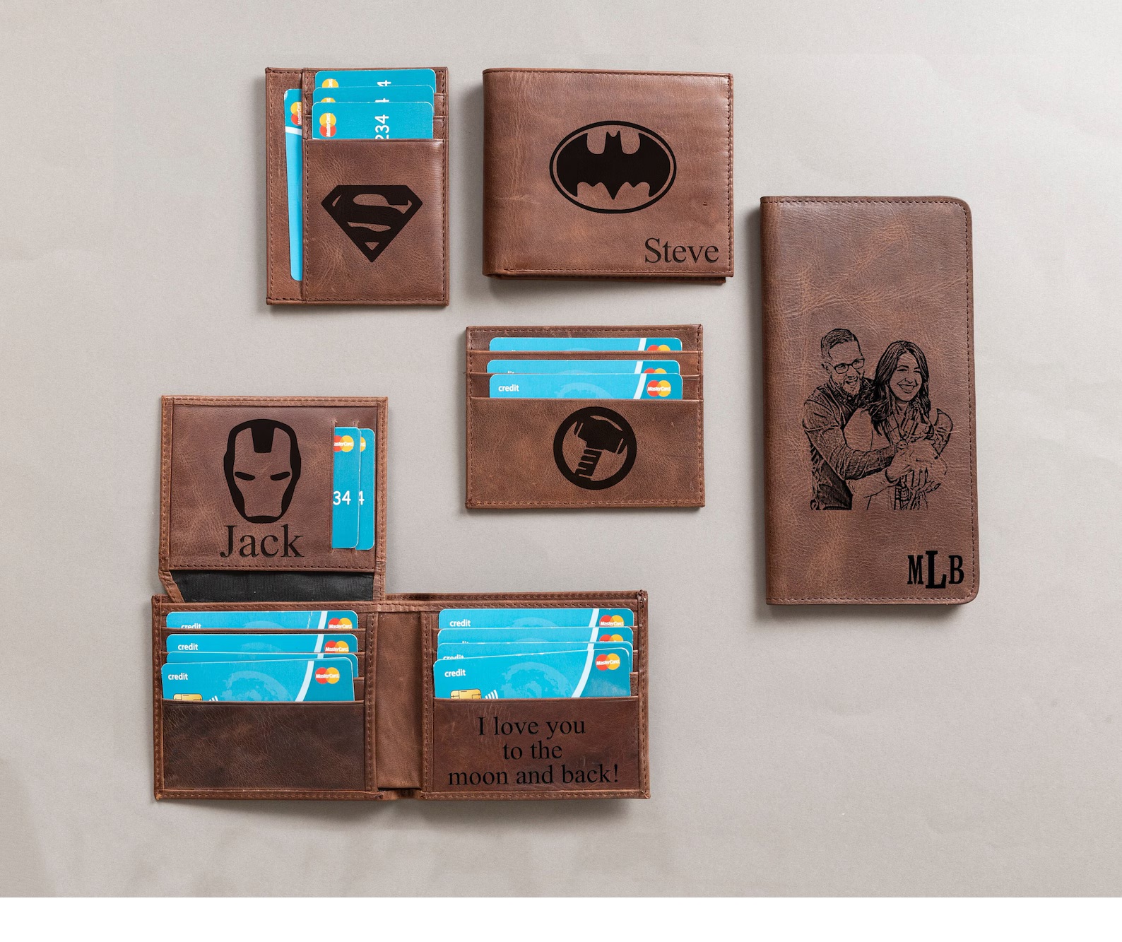 A series of brown leather wallets featuring various superhero logos and personalized messages