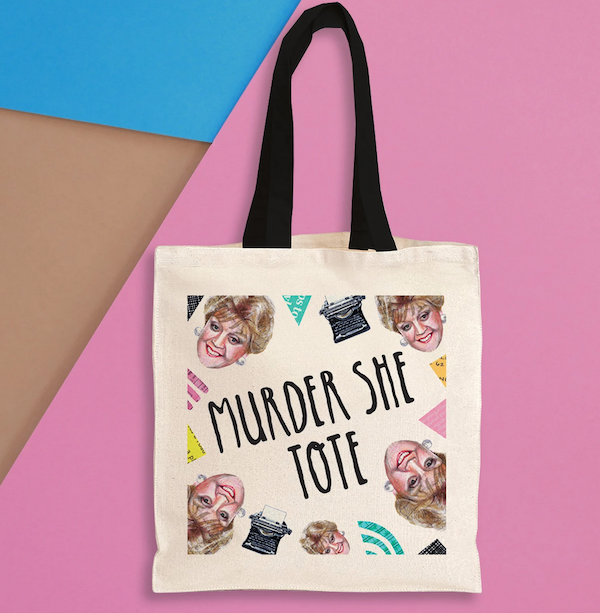 a beige tote bag with a black handle with images of Angela Lansbury's face and typewriters that says Murder She Tote