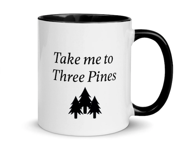 a white mug with a black handle and graphic image of pine trees that says Take Me To Three Pines