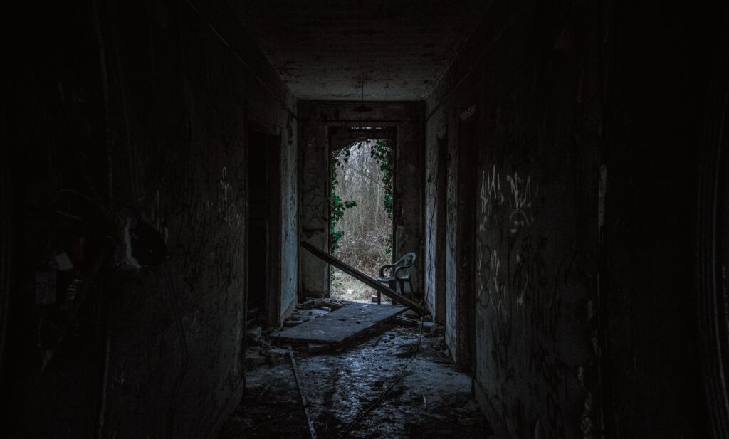 Dark hallway leading to lighted door opening