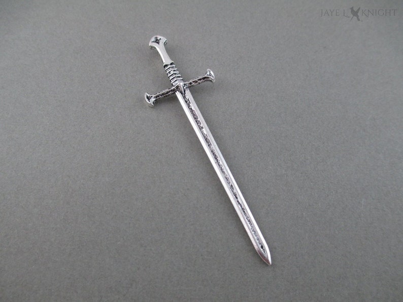 Image of a silver mini sword to be used as a bookmark. 