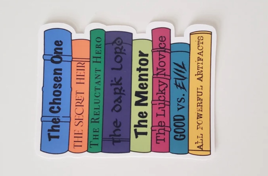 Image of a sticker featuring eight colorful book spines. Each spine has a fantasy trope on it, including "The chosen one," "The dark lord," or "the mentor."