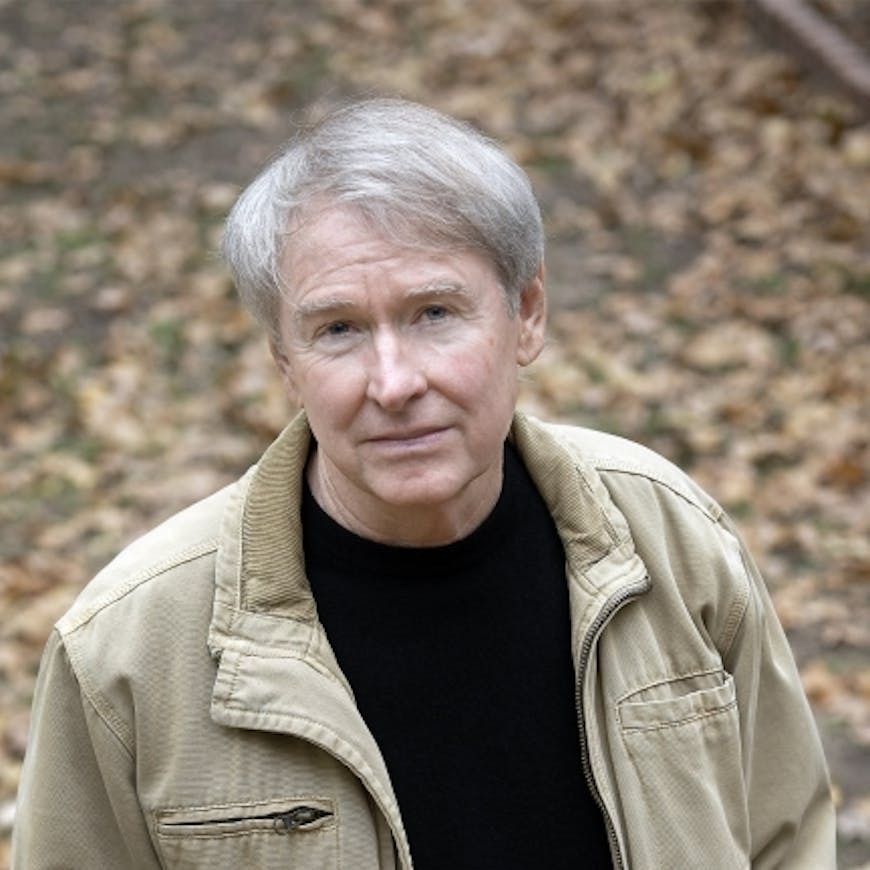 headshot of author Ben Fountain wearing a black tshirt and tan jacket 