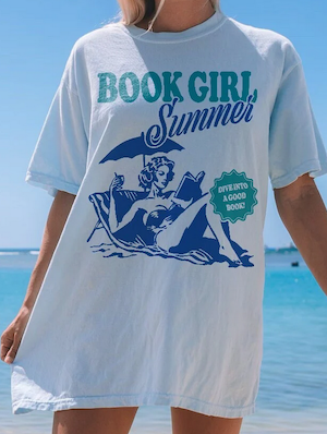 tshirt with graphic illustration of a woman reading on the beach that says "book girl summer / dive into a good book"